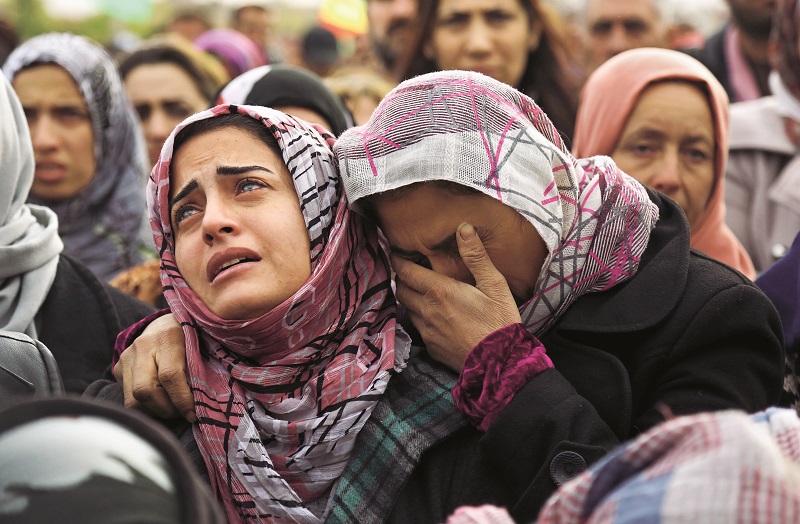 TOPSHOT - The sister (L) of Mohammed Ismael, who died in one of three suicide car bombings claimed by the Islamic State (IS) group in the nearby town of Tal Tamr earlier this week, mourns during his funeral in Qamishli, a Kurdish-majority city in Syria's northeastern Hasakeh province, on December 13, 2015. Tal Tamr, in the Khabur region, is controlled by Kurdish forces and has been targeted in the past by IS jihadists, who in February overran much of Khabur and kidnapped at least 220 Assyrian Christians. AFP PHOTO / DELIL SOULEIMAN / AFP / DELIL SOULEIMAN (Photo credit should read DELIL SOULEIMAN/AFP/Getty Images)