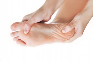 Pain in the foot. Massage of female feet. Pedicures. Isolated on white background.